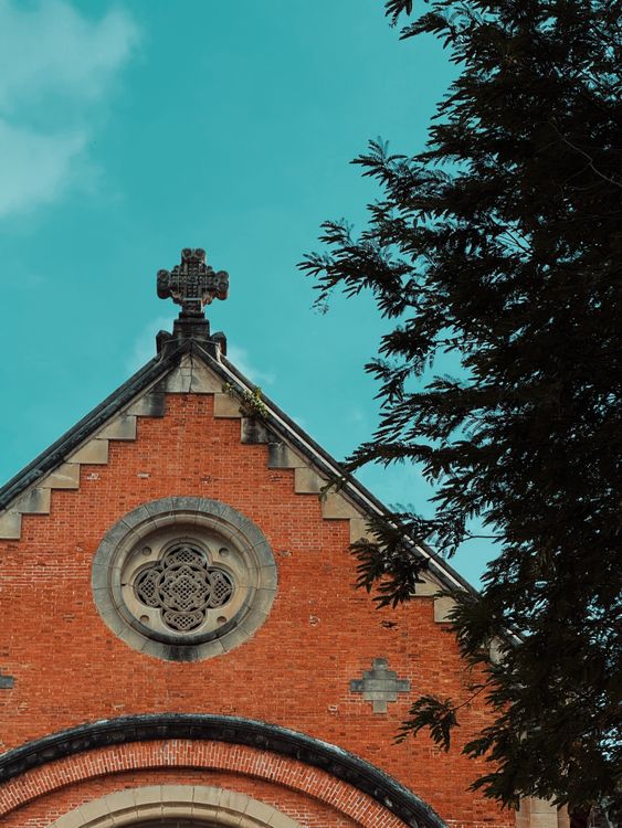 Historic Red Brick Church Facade against Blue Sky · Free Stock Photo