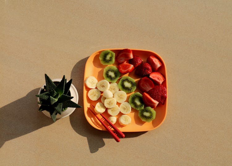 Sliced Kiwis, Bananas, And Strawberry On Plate