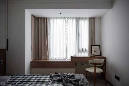 Free Stylish minimalist bedroom featuring a cozy bed, desk, and natural light through a window. Stock Photo