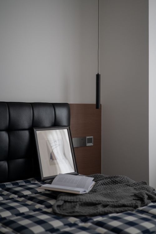 Free Modern bedroom interior with a cozy atmosphere, featuring artwork and a stylish pendant light. Stock Photo