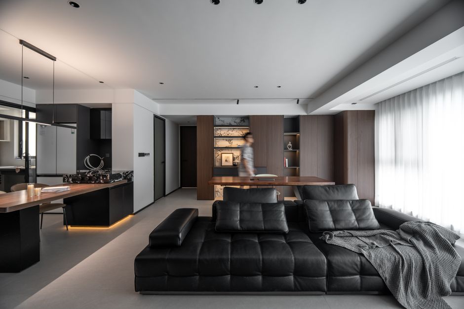 Stylish living room with black sofa and kitchen area in a modern apartment. - High Quality Performance Evaluation