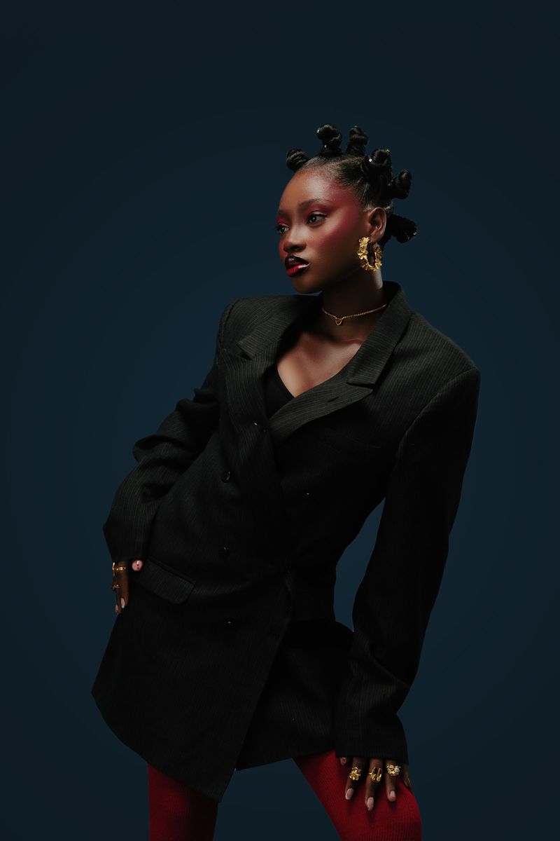 Woman in a black blazer with statement jewelry