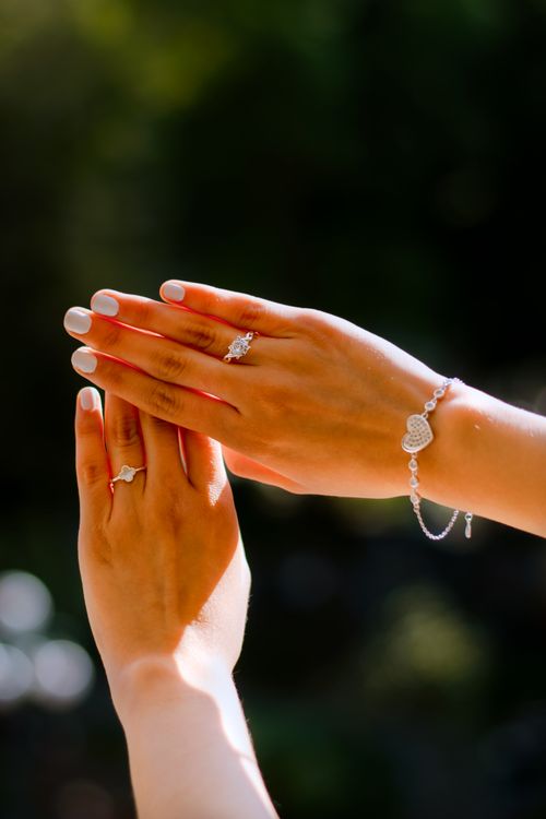 Free Two hands adorned with rings and bracelet in natural light, showcasing elegance and style. Stock Photo