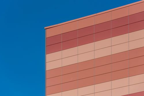 Free Minimalist architectural facade with geometric patterns under a vivid blue sky. Stock Photo