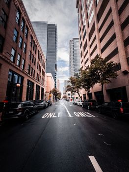 A vibrant city street lined with tall buildings and clear road markings.