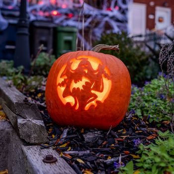 Close-up of a carved pumpkin with a glowing witch design, perfect for Halloween atmosphere.（イメージ）