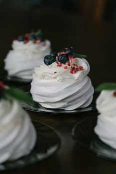 Delicious mini pavlovas adorned with cream and fresh berries, perfect for gourmet desserts.