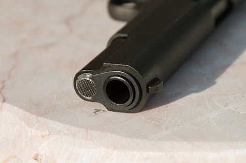 Free Black Metal Gun on White Surface Stock Photo