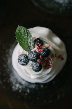 Delicious mini pavlova topped with blueberries, red berries, and whipped cream, perfect for desserts.