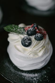 Gourmet pavlova topped with blueberries and cream, perfect for elegant soirees.