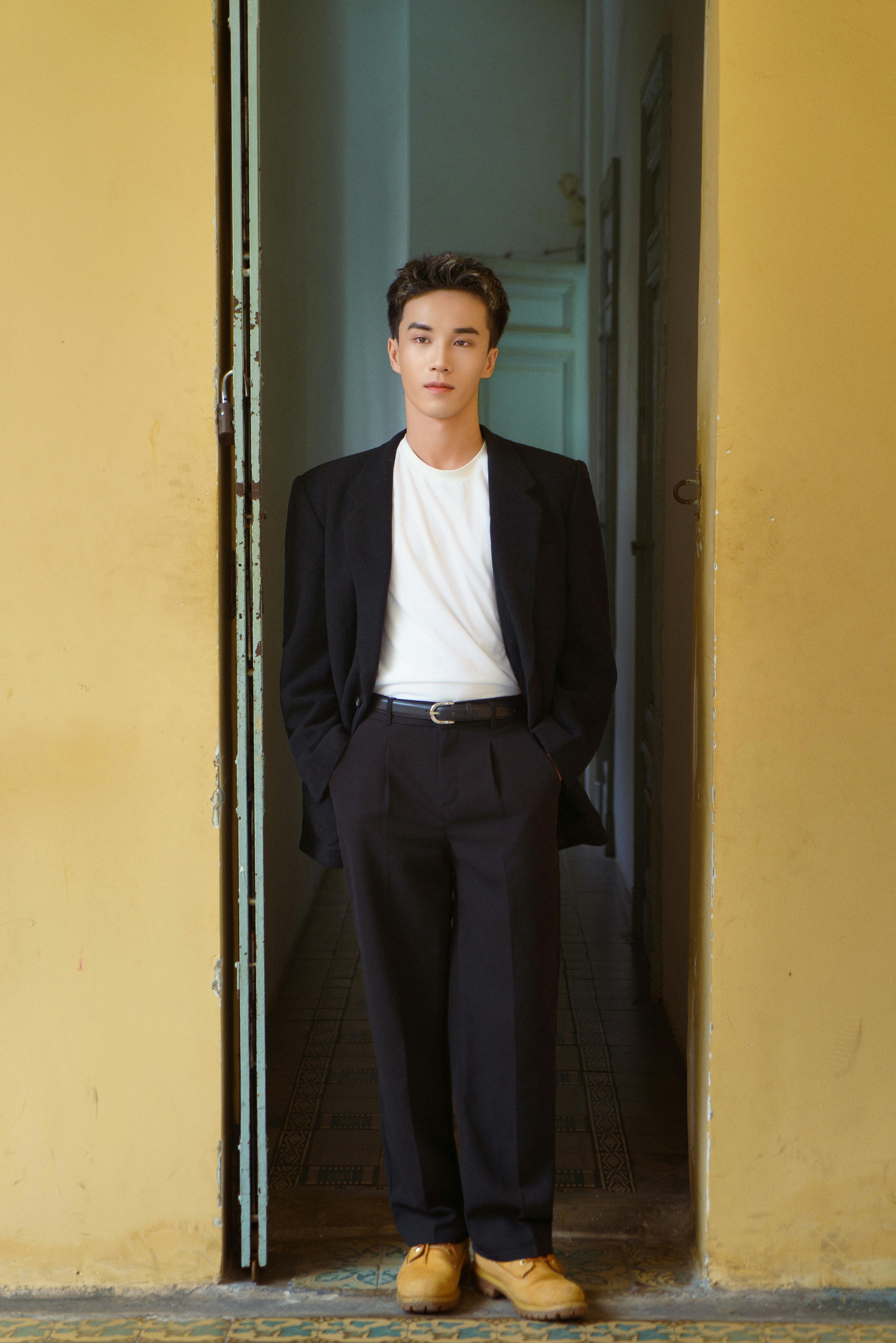 Full-length portrait of a man in a classic suit in a vintage style doorway in Ho Chi Minh City.
