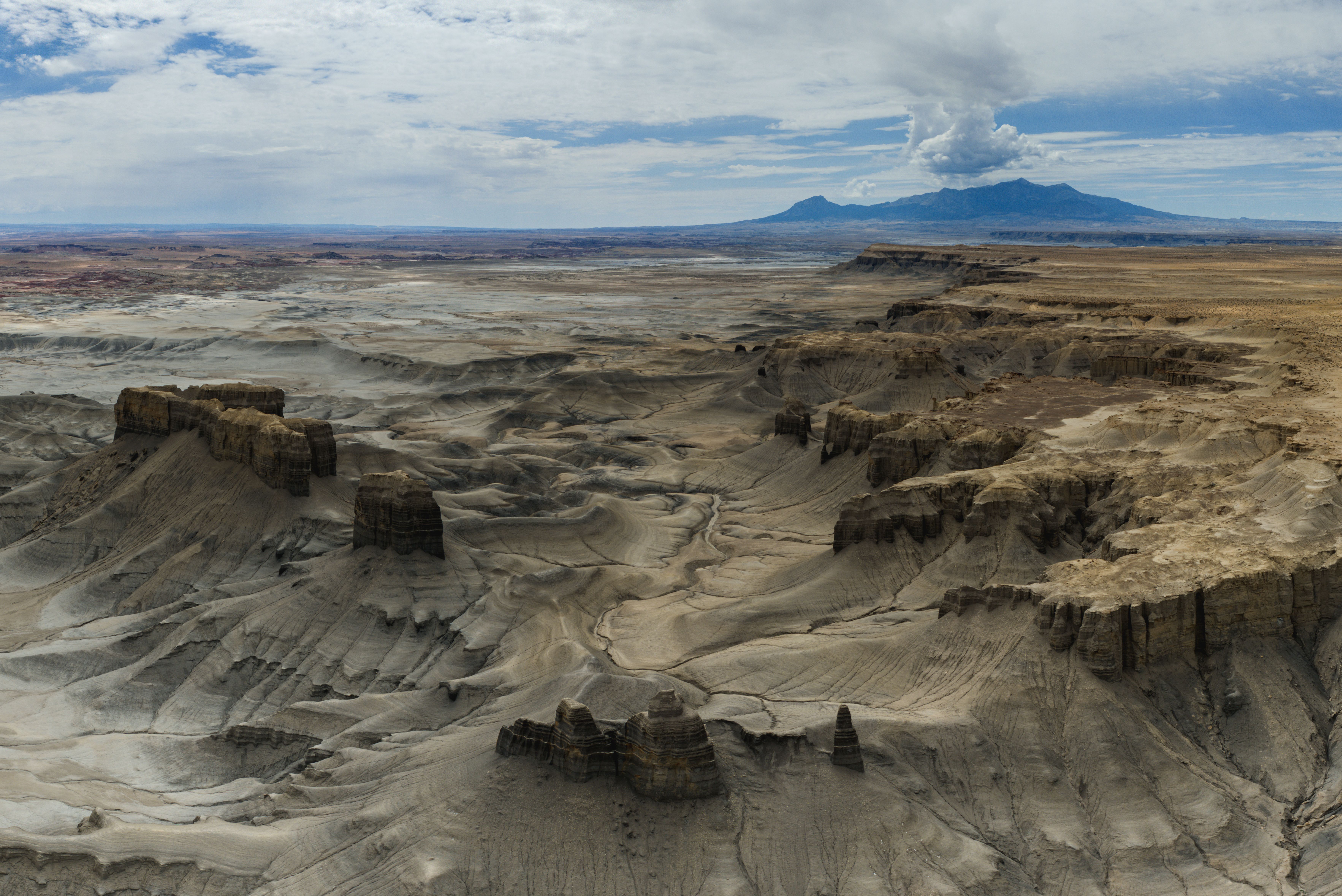 Spectacular Canyon Country Sunset Helicopter Tour - 60 minutes Review 2026 - Stunning aerial shot of Utah's arid terrain showcasing rugged mesas and distant mountains under a cloudy sky.