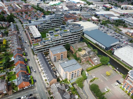 Aerial shot showcasing modern urban housing and industrial area under daylight.