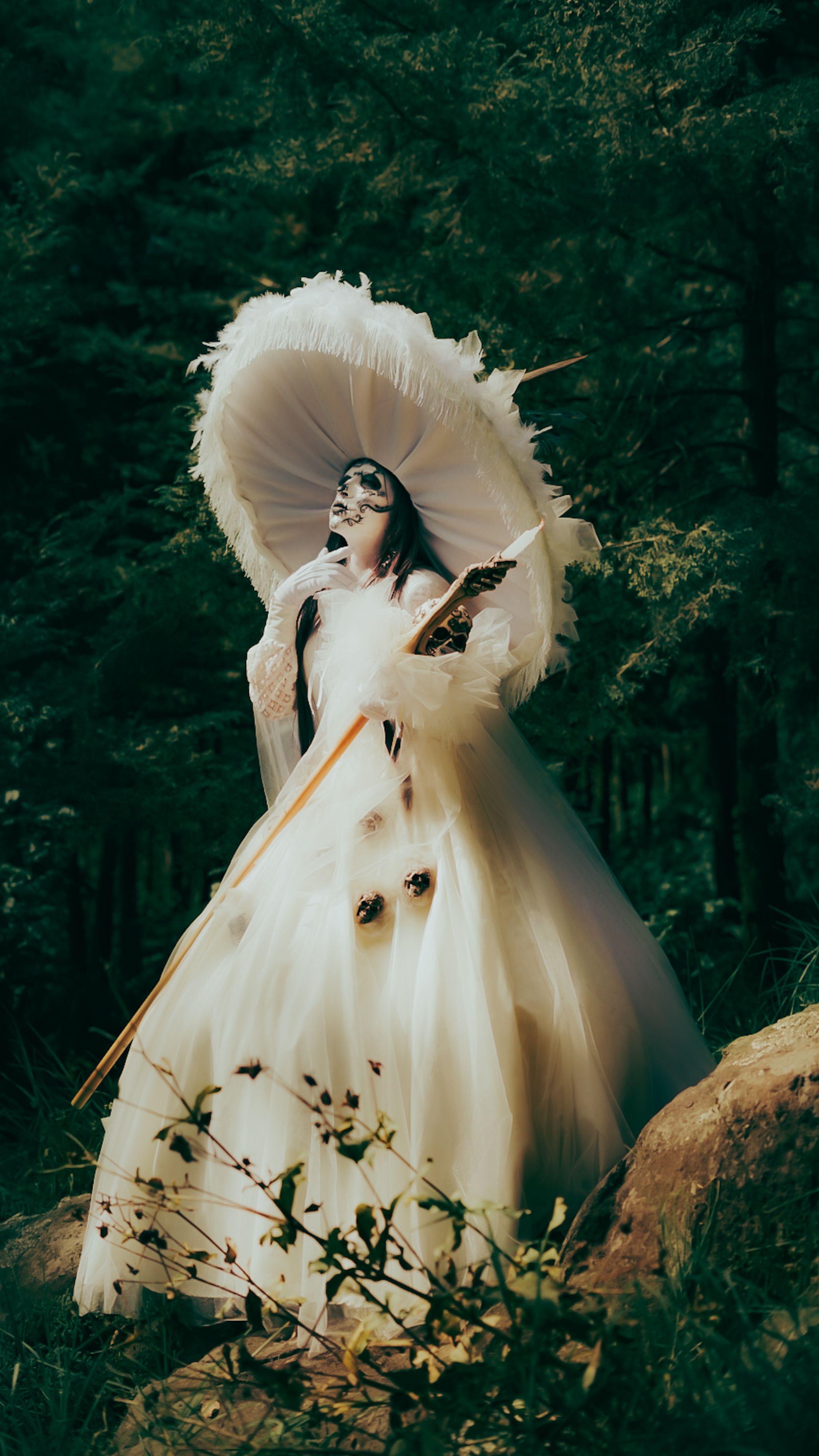 A fairy-like figure dressed in a white gown stands in a forest carrying an elegant umbrella, evoking a mythical atmosphere.