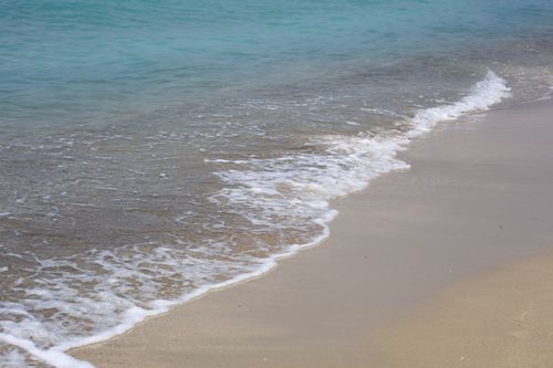 Free Peaceful beach scene with gentle waves lapping on the sandy shore. Stock Photo