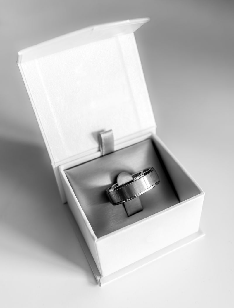 Wide brushed silver tungsten wedding band displayed in an open white ring box — FoundryCut