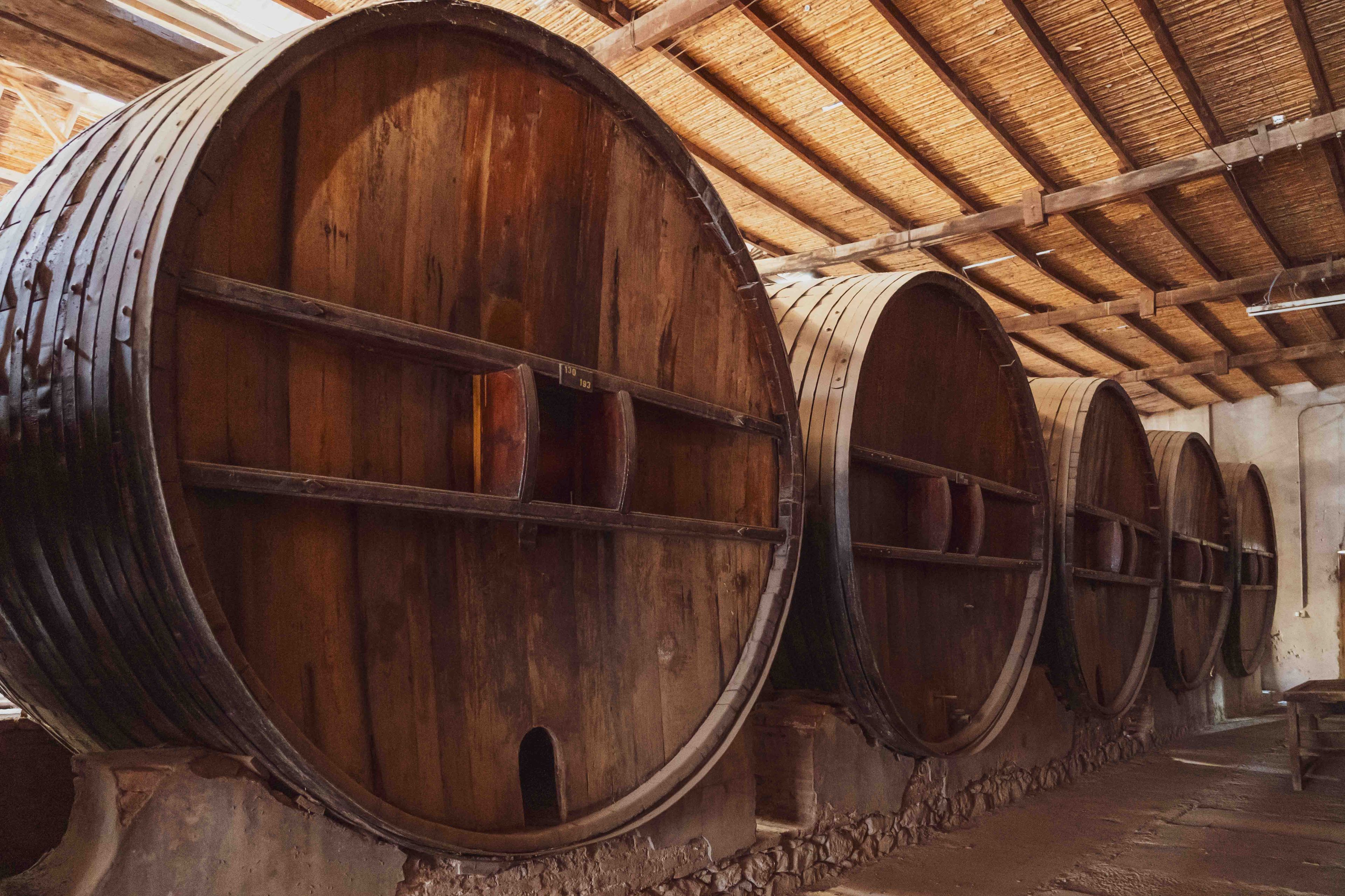 Large wooden wine barrels in a historic San Juan, Argentina winery.