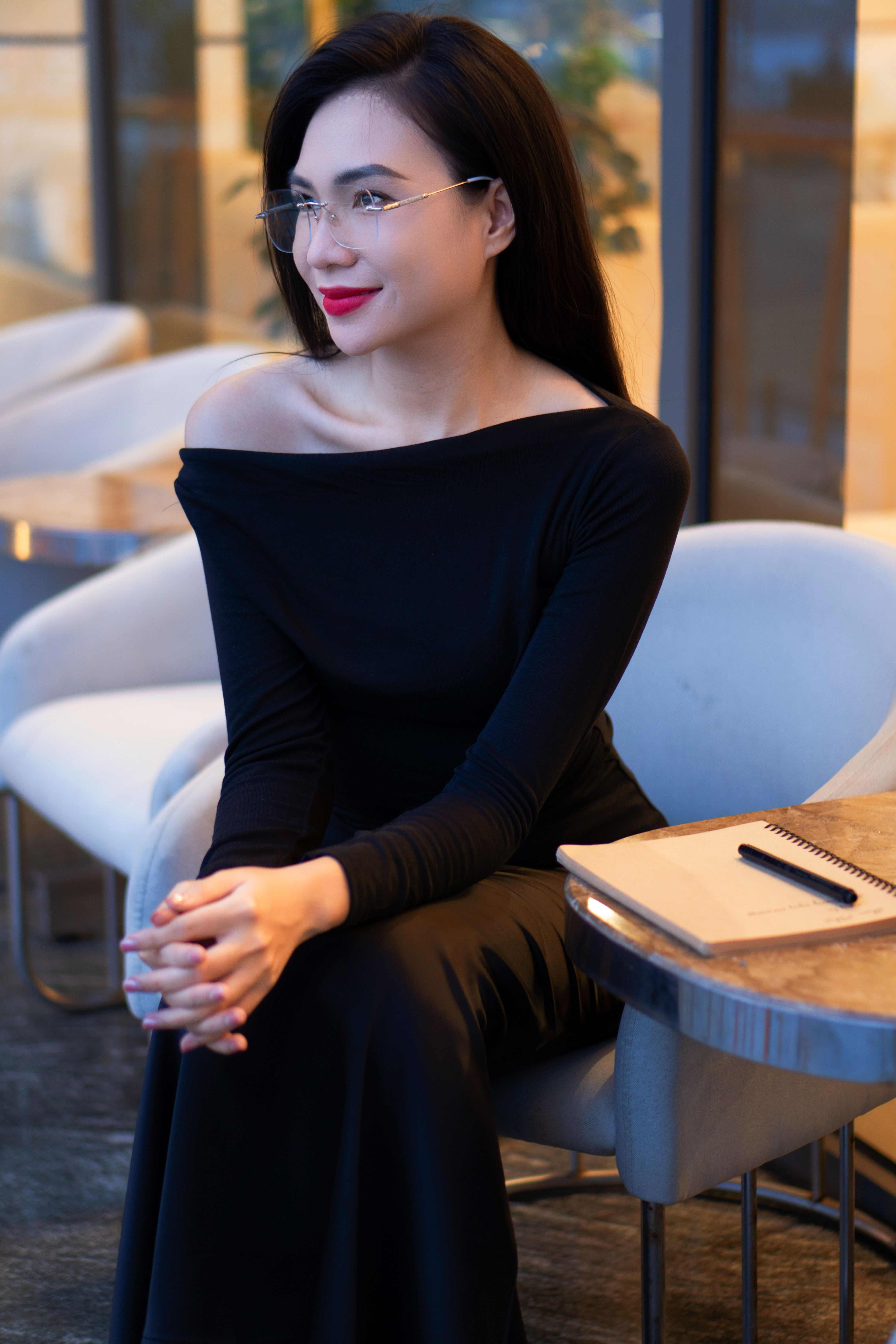 Elegant Woman in Black Dress Seated Indoors · Free Stock Photo