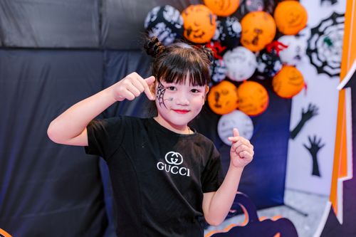 Free Young girl in Halloween costume with face paint, posing festively indoors. Stock Photo