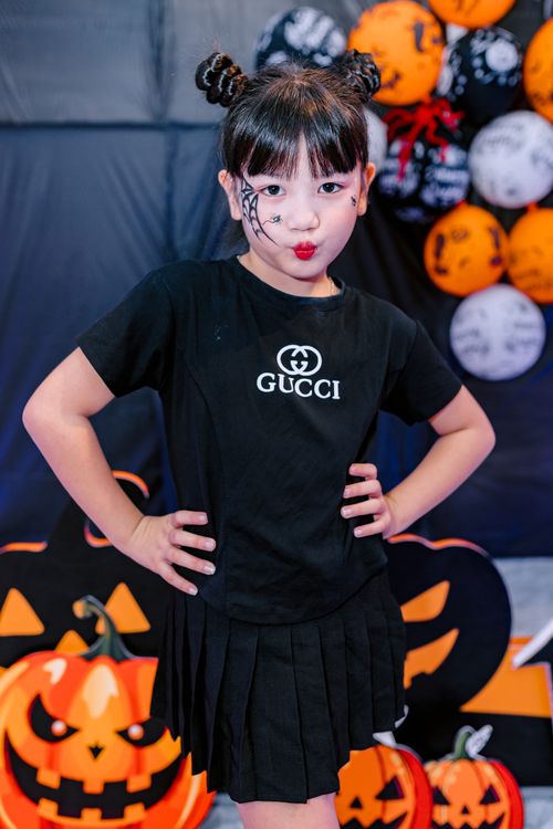 Free Little girl with face paint and costume poses for Halloween indoors. Fun and festive mood. Stock Photo
