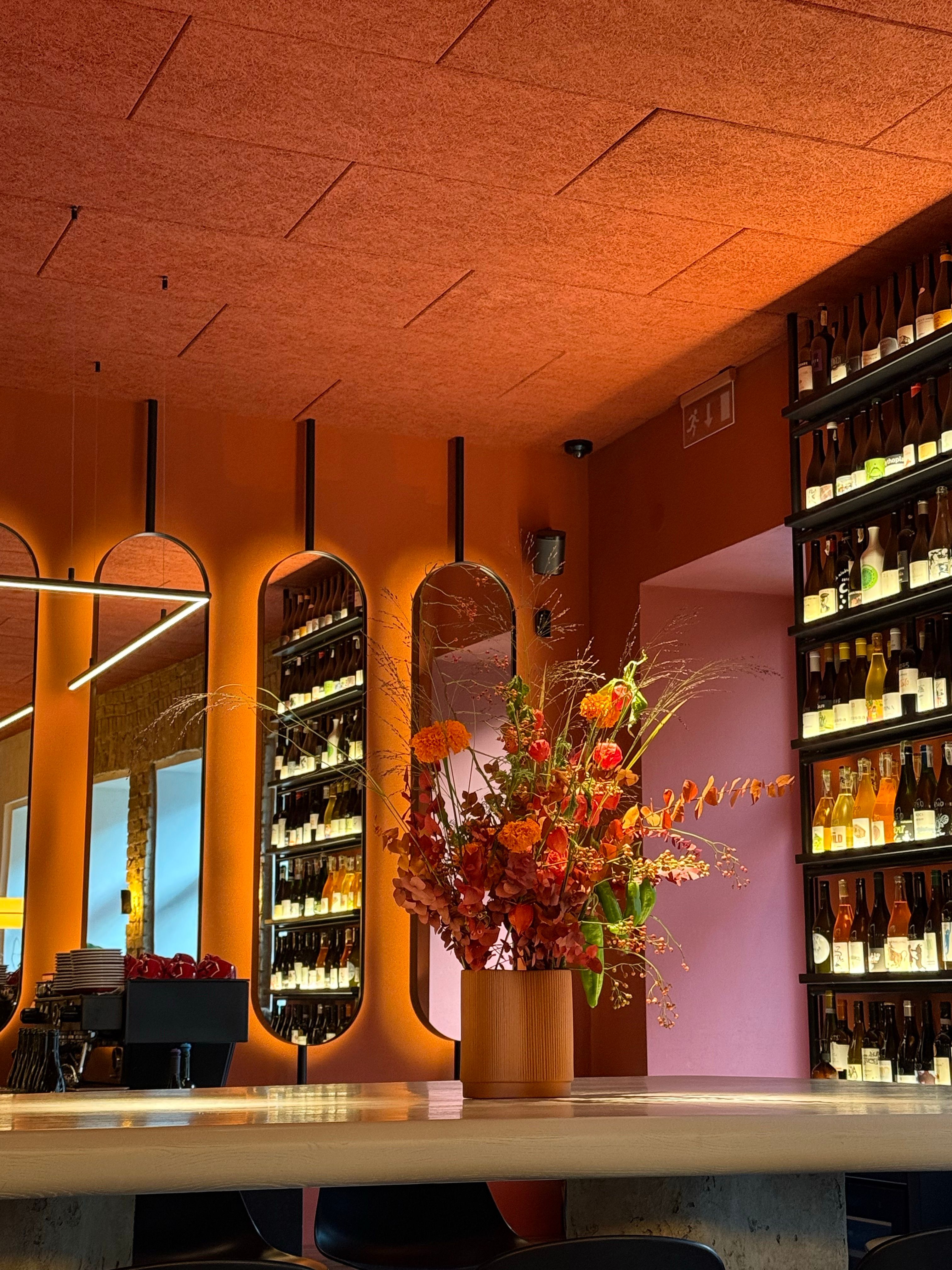 Modern Bar Interior with Orange Floral Arrangement · Free Stock Photo