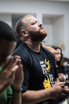 Man deeply focused during a gathering, showing emotion and introspection.