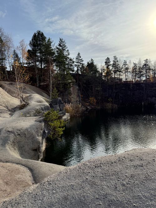 Free Quiet lake surrounded by pine trees and rocky cliffs during fall. Stock Photo