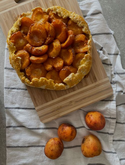 Free Freshly baked apricot galette on a cutting board, perfect for summer baking. Stock Photo
