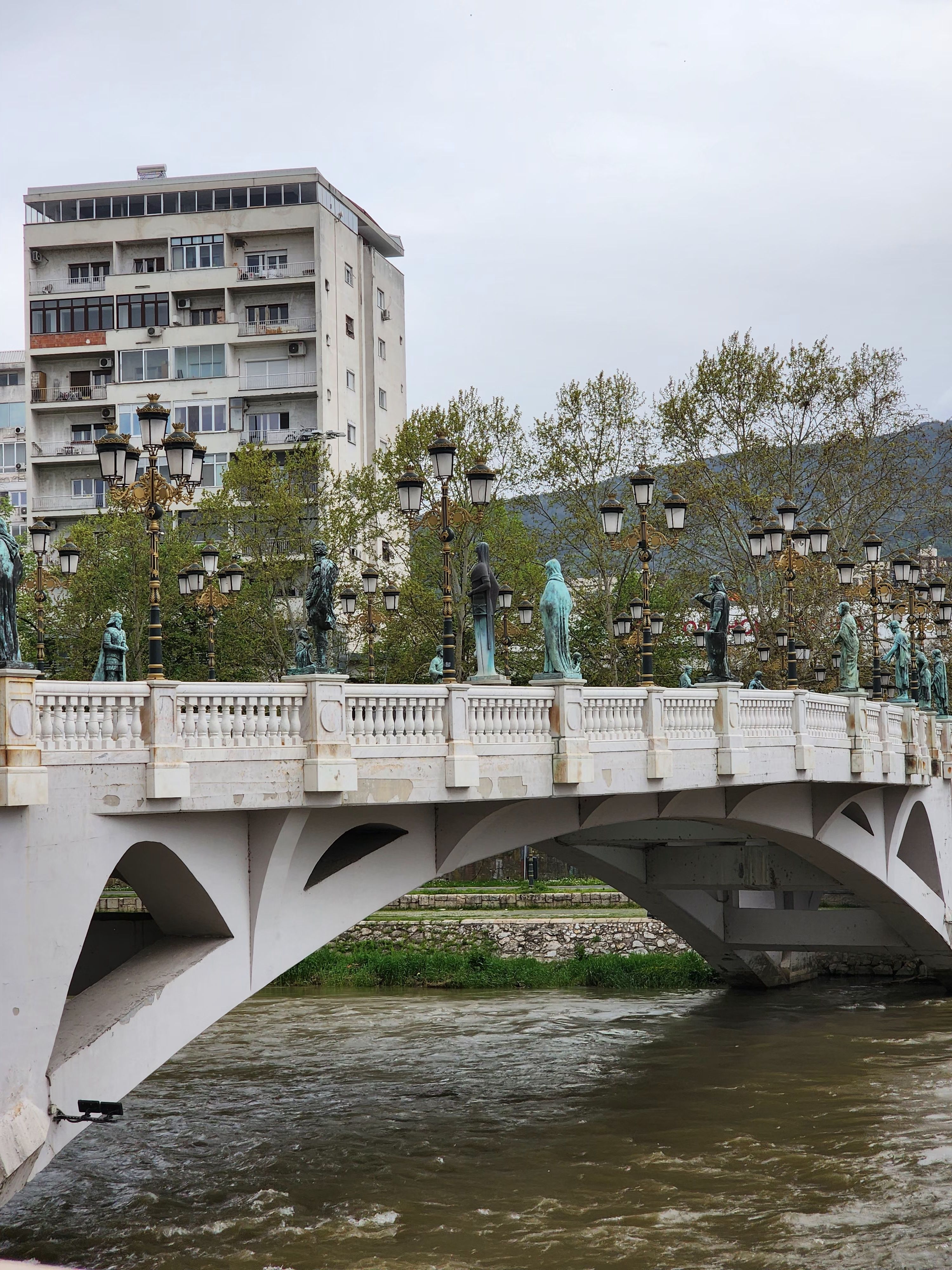 Elegant bridge with statues and decorative lamps in Üsküp, North Macedonia.