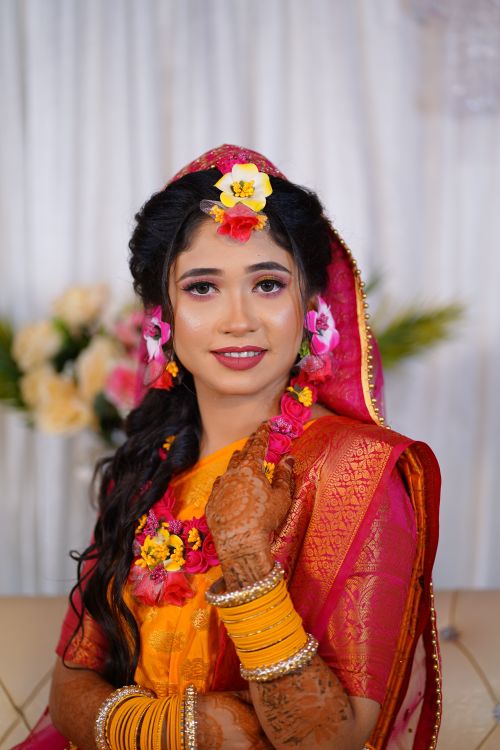 Free A beautiful bride in colorful traditional attire adorned with vibrant floral jewelry. Stock Photo