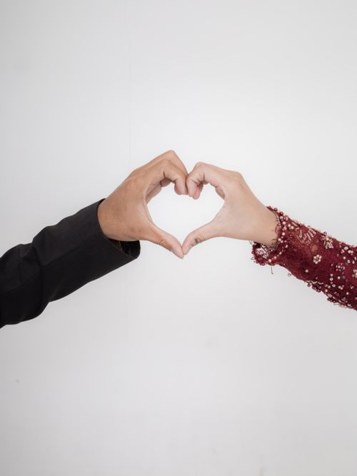 Free Two hands forming a heart shape symbolizing love and connection, set against a minimalist white background. Stock Photo