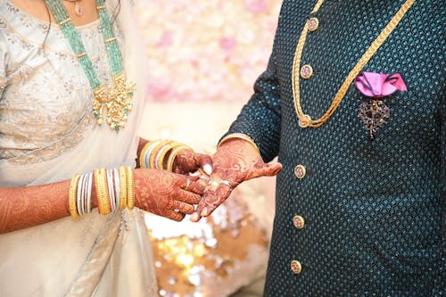 Crop Indian newlyweds in traditional wear