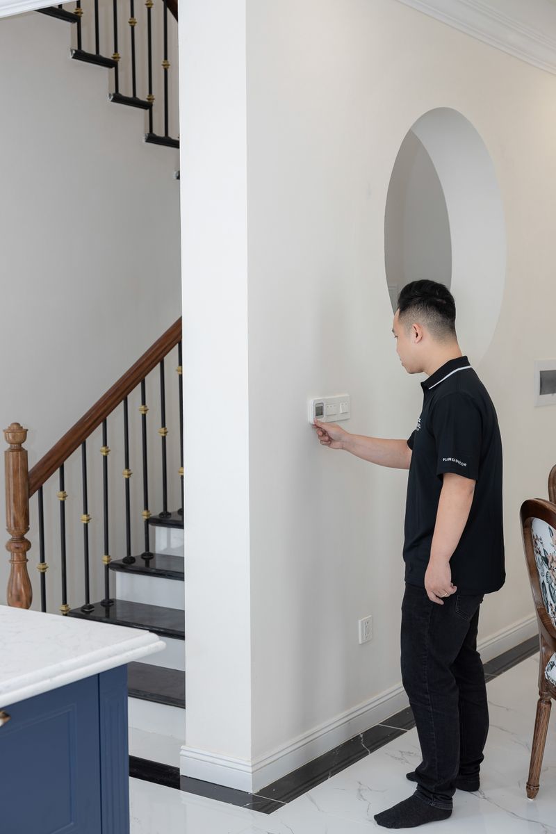 Man adjusting thermostat in modern home