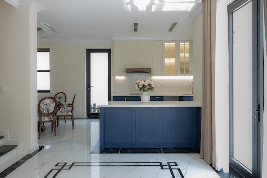 Bright and elegant modern kitchen featuring blue cabinetry and marble flooring.