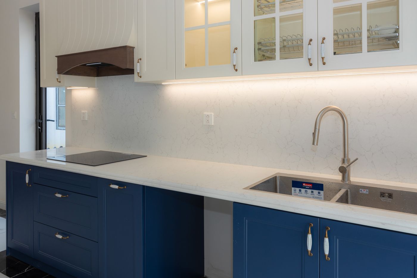 Stunning open kitchen with dark navy cabinetry and gold hardware