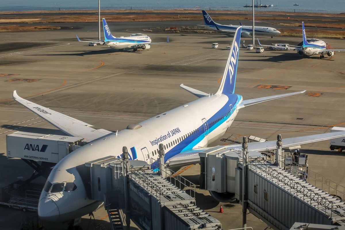 Aircraft parked at an airport terminal gate with a jet bridge