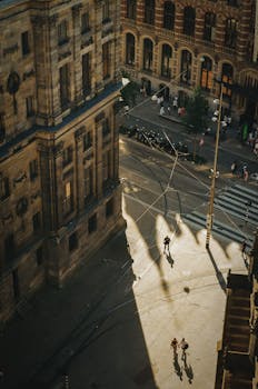 Aerial view of a city street with long shadows, capturing urban life at sunset.