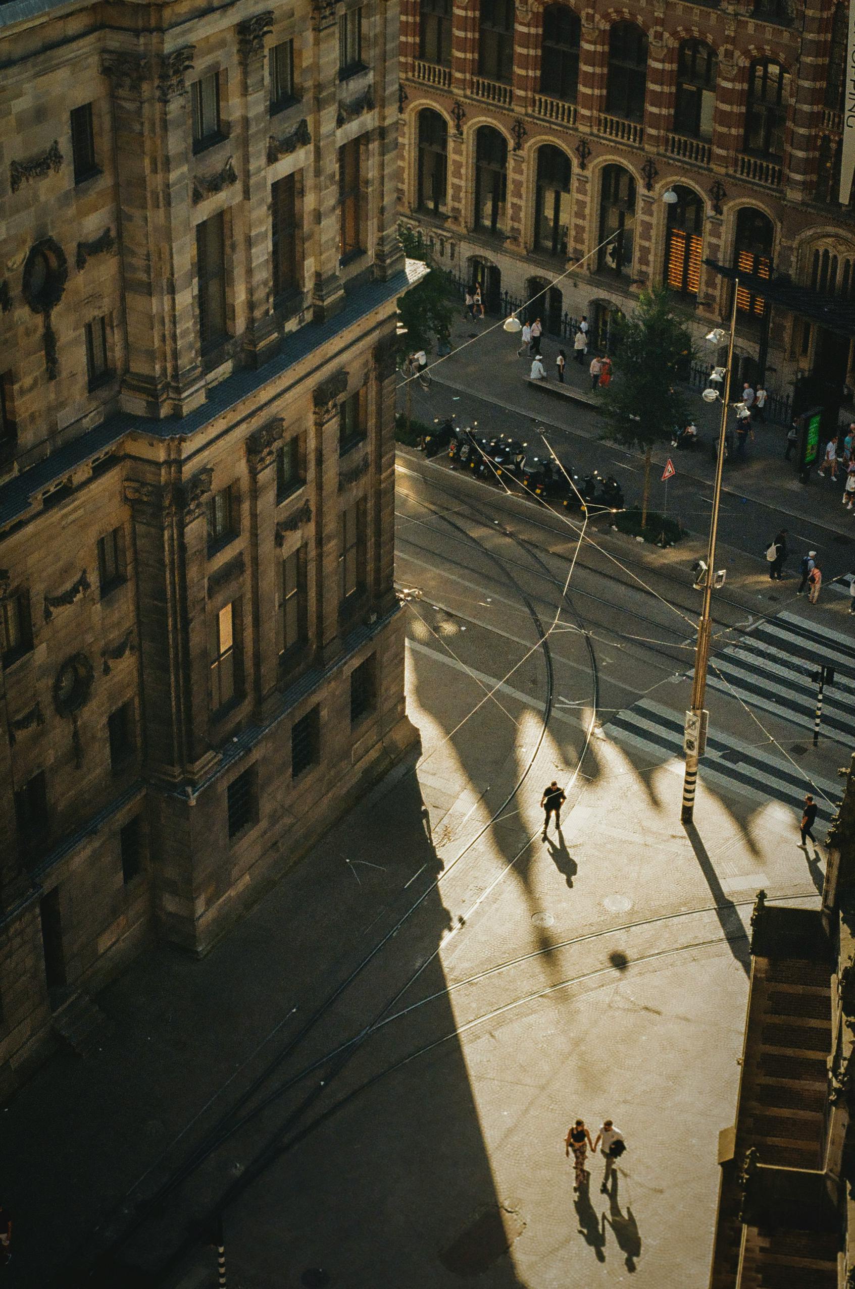 Free Aerial view of a city street with long shadows, capturing urban life at sunset. Stock Photo