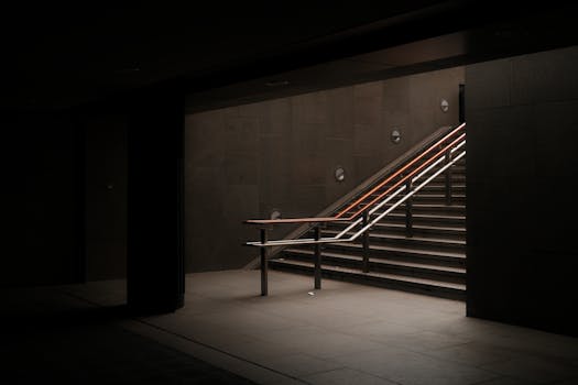 A dimly lit underground staircase offering a minimalist and moody atmosphere.