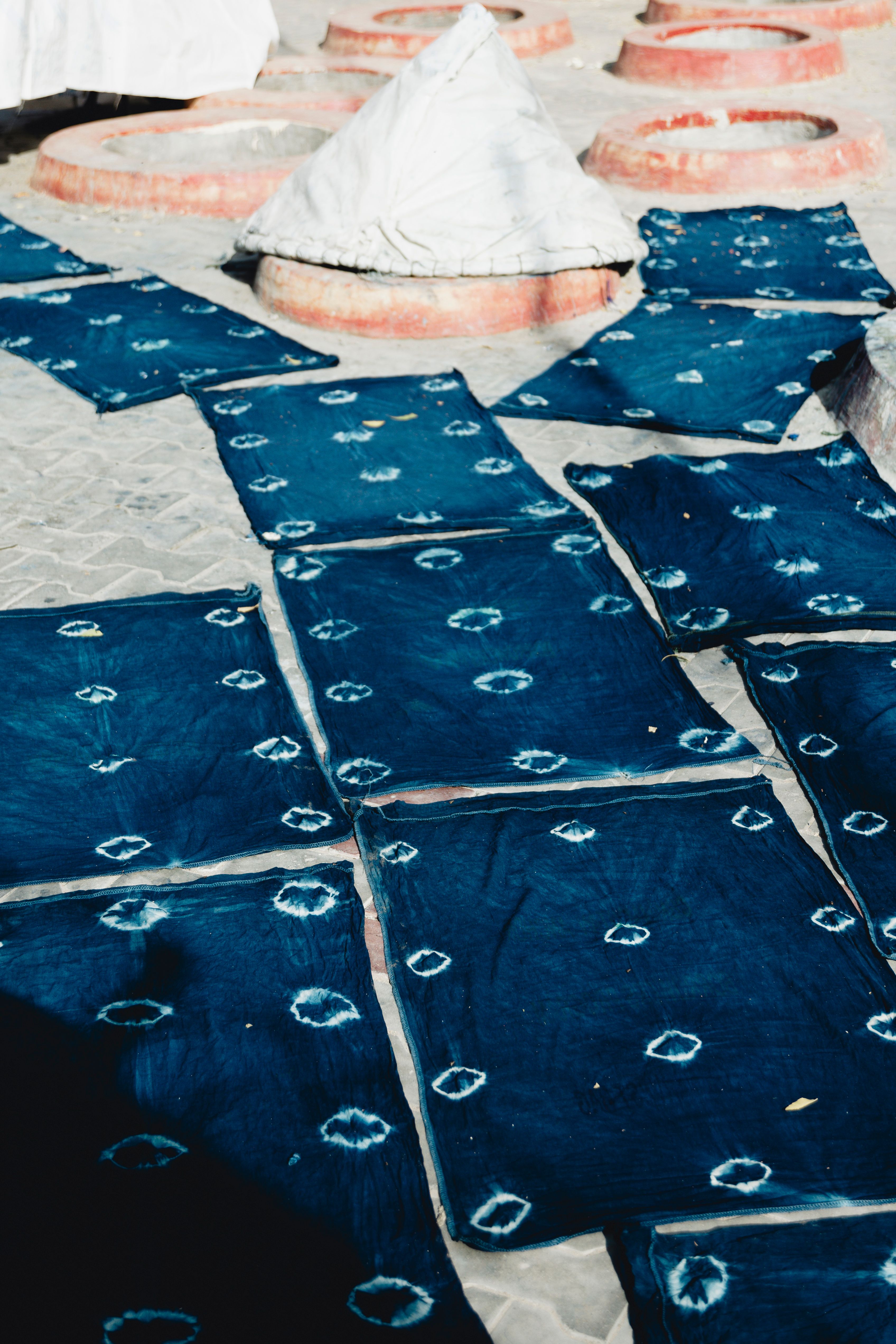 Indigo-dyed textiles drying outdoors, showcasing traditional dye methods.