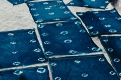 Indigo-dyed textiles drying outdoors, showcasing traditional dye methods.