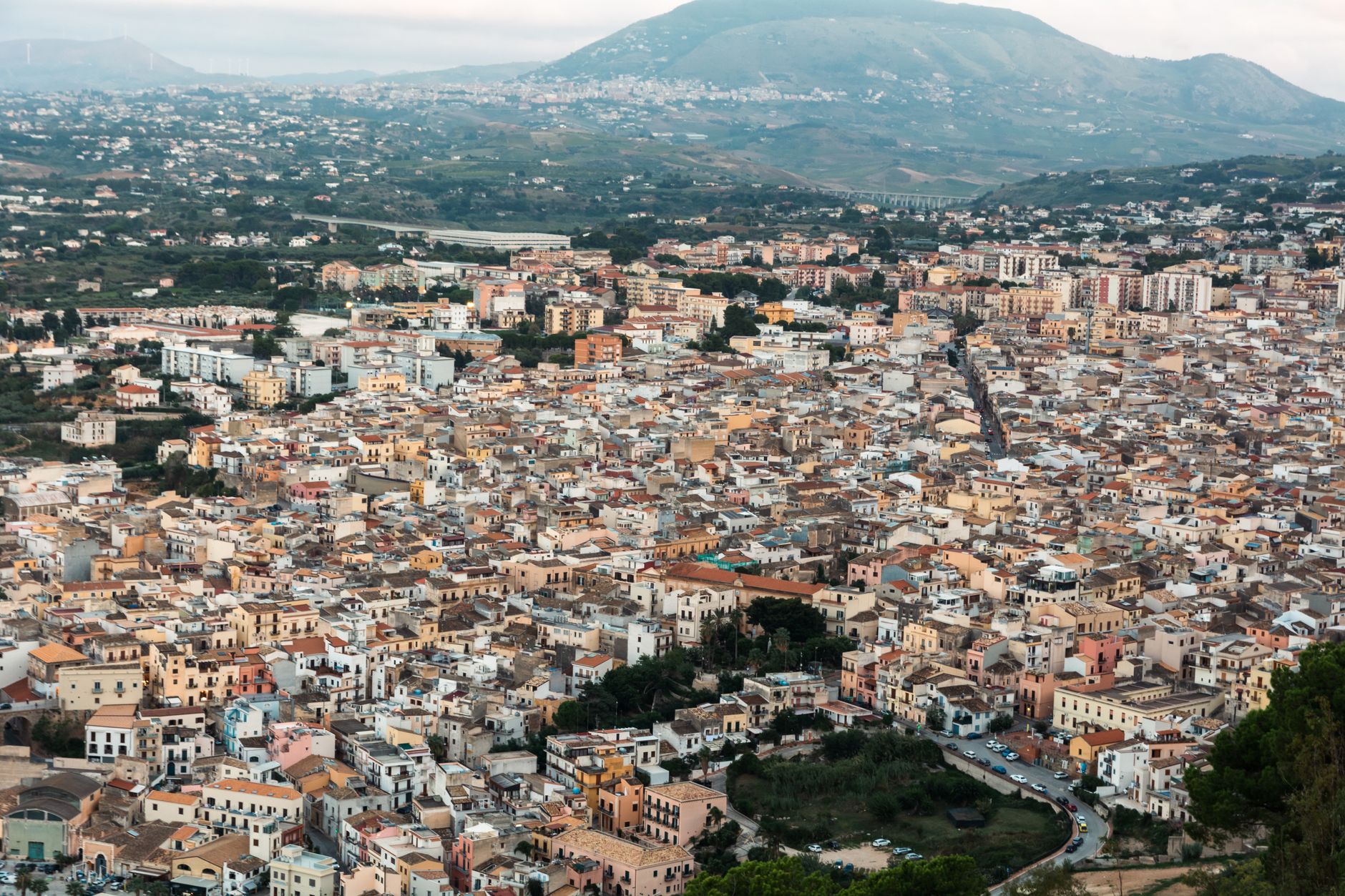Aerial view of Caltanissetta with dense buildings and hilly backdrop in Sicily.
