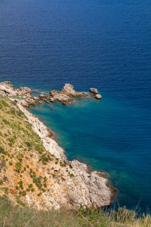 Free Scenic aerial view of a rocky coastline meeting the deep blue sea, perfect for travel inspiration. Stock Photo