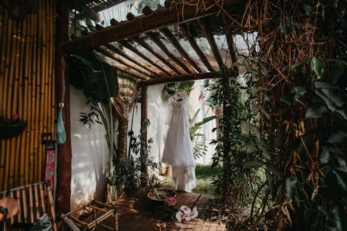 бесплатная Белое платье висит рядом с садом Стоковое фото
