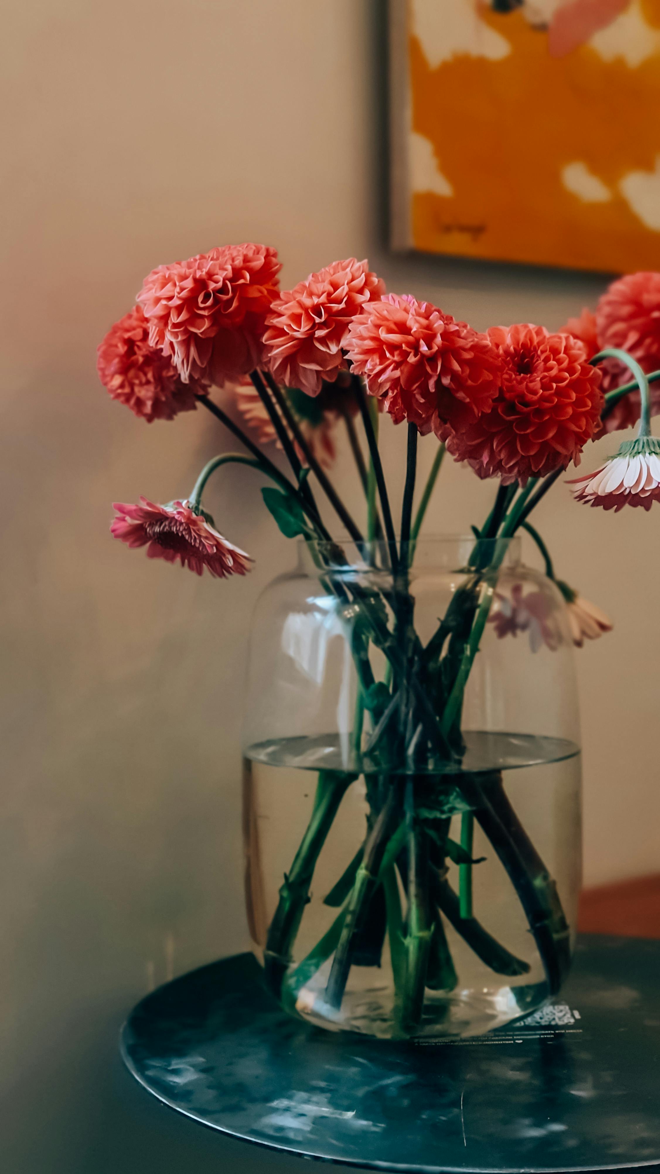 [ColoSach]-bright-red-flowers-beautifully-arranged-in-a-clear-glass-vase-on-a-round-table-indoors.