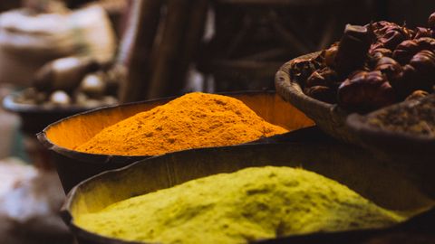 Colorful spices on display in a traditional market setting, emphasizing vibrant cultures.