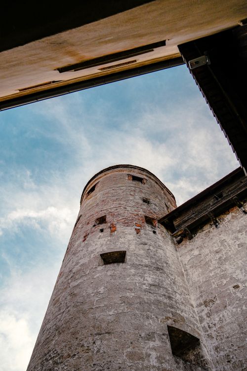 Free A low angle view of an old stone tower against a cloudy sky, showcasing historical architecture. Stock Photo