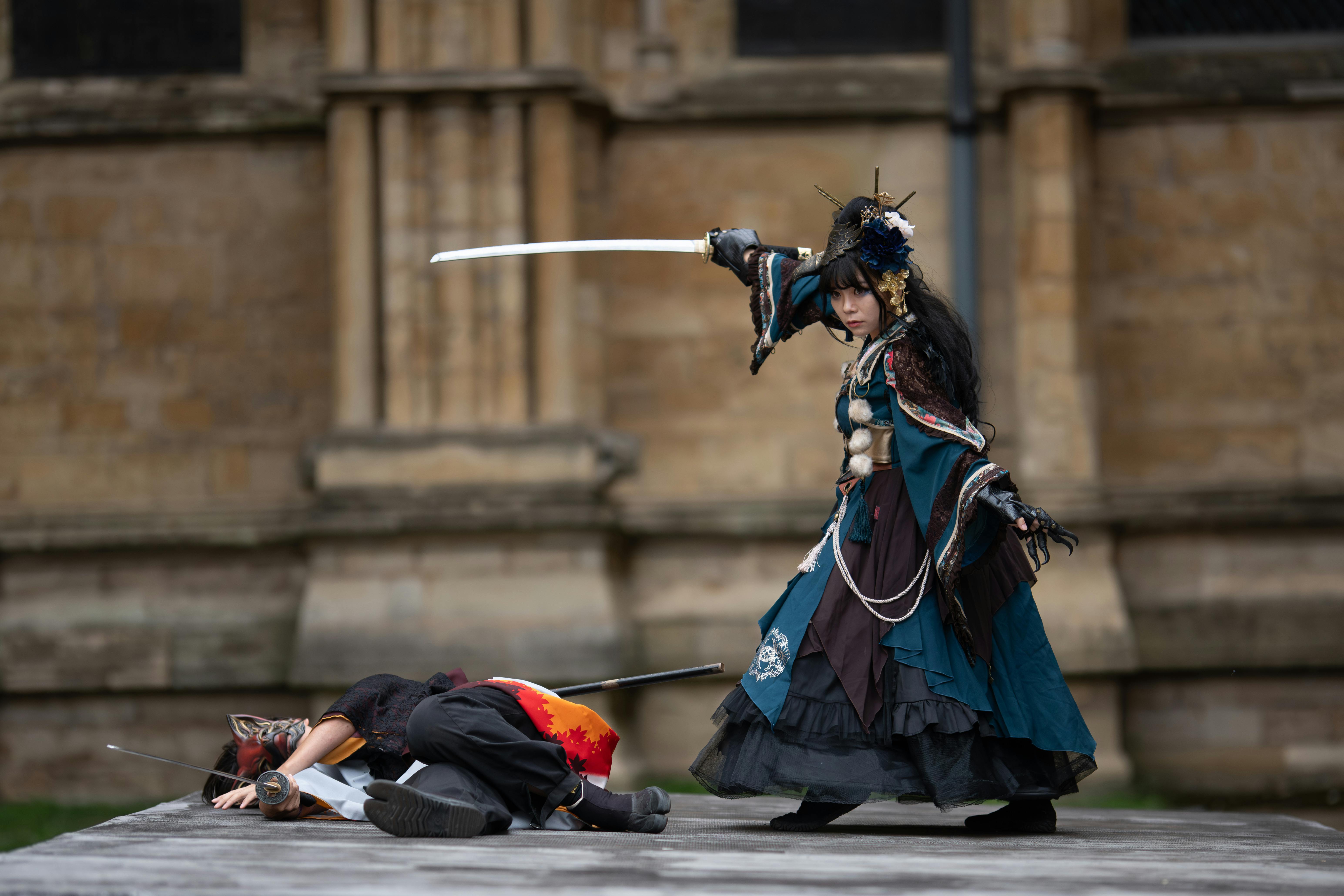 Ücretsiz Kılıç dövüşü ve gösterişli kostümlerle dramatik açık hava cosplay sahnesi. Stok Fotoğraflar