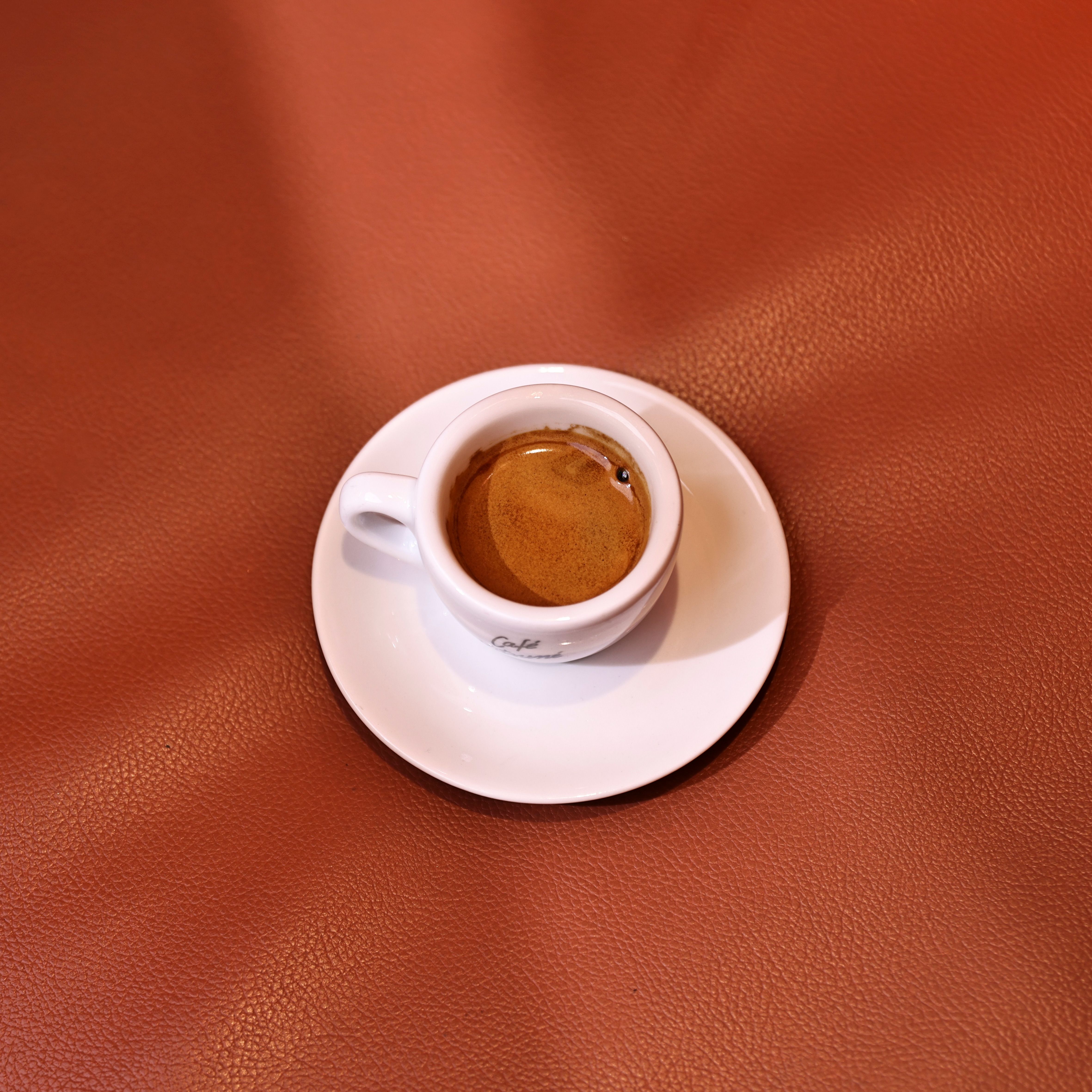 White espresso cup on a leather surface — photo by Swarup Sarkar on Pexels