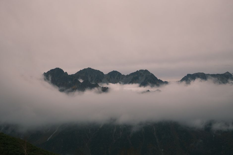 Dramatic misty view of mountain peaks in Azumino, Nagano, Japan, at twilight.
